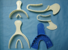 Figure 2: Various types of impression trays include (clockwise from bottom left) a long dual arch triple tray, a short anterior triple tray, the long and short quadrant triple trays, and a mandibular full-arch plastic stock tray used for separate arch impressions.